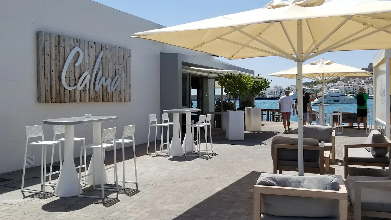 Calma terrace in Marina Ibiza with outdoor seating, parasols and harbour views