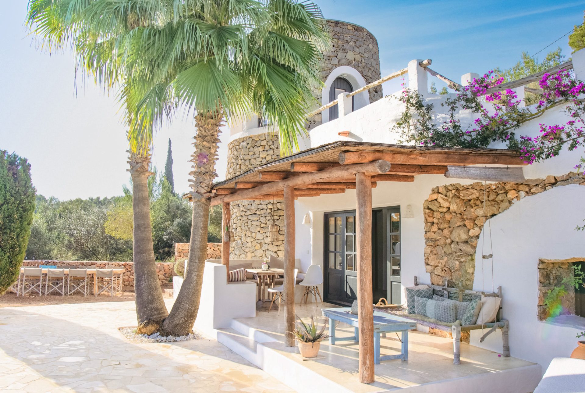 Ibiza villa with whitewashed and stone walls, palm trees and a shaded terrace